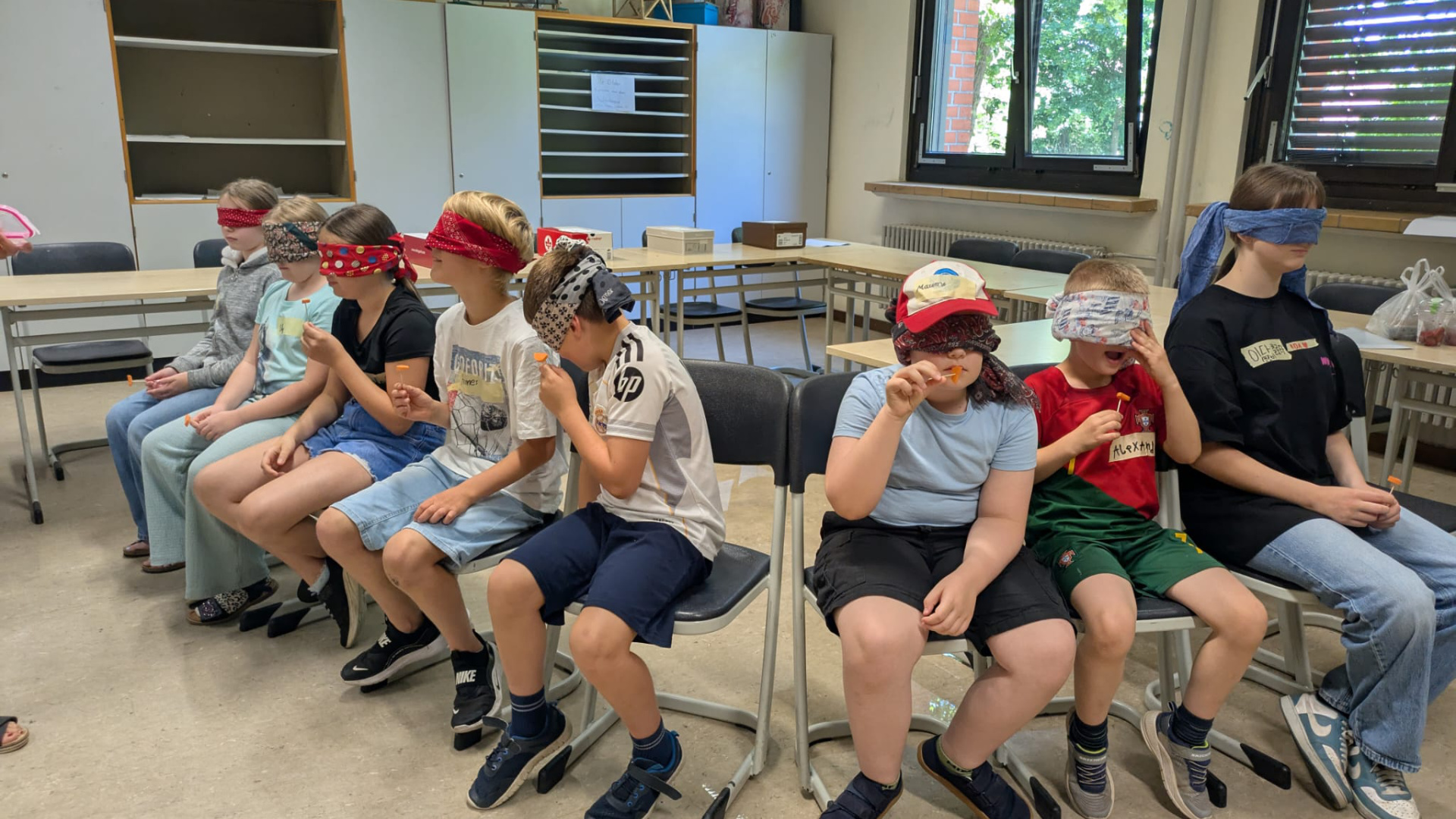 Kinder erraten mit verbundenen Augen Zutaten.